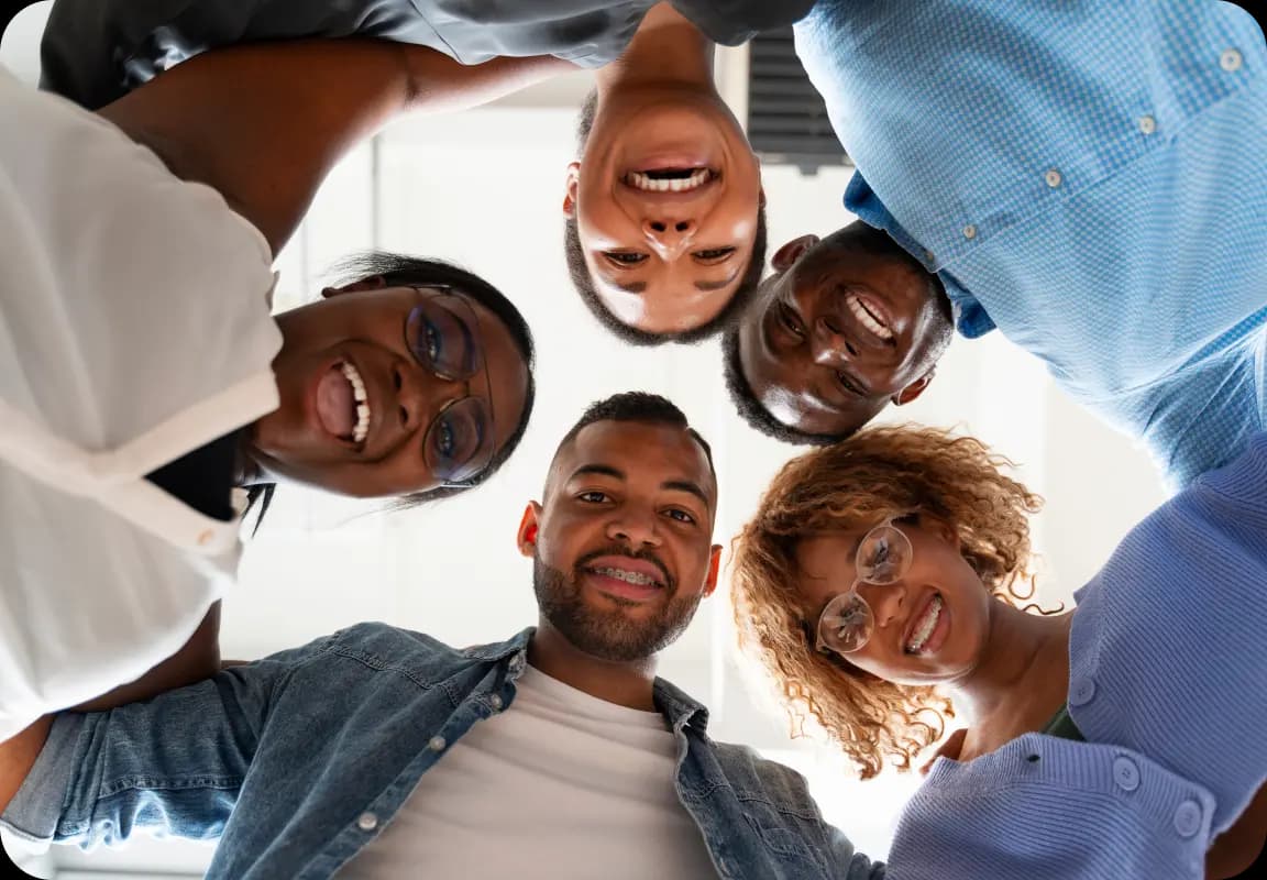 Diverse group of people looking down at camera in a circle